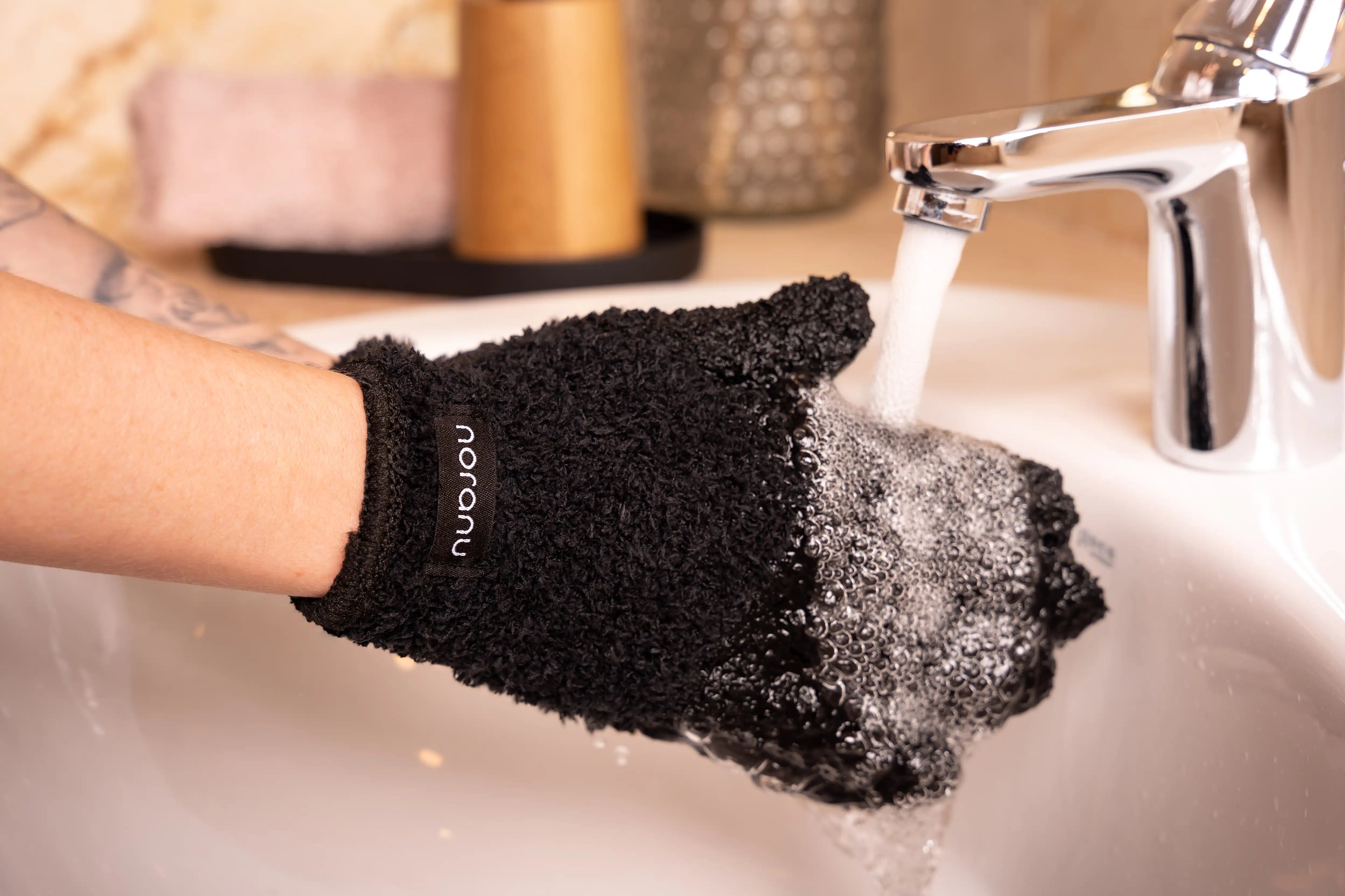 Abschminkhandschuh in schwarz wird mit Wasser ausgespült für die wiederverwendbare Gesichtsreinigung