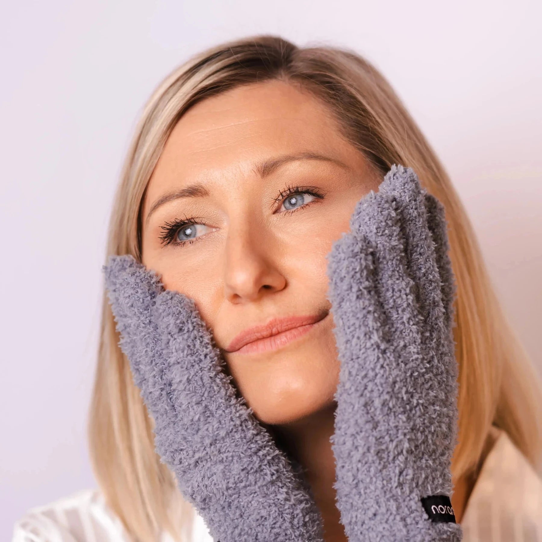 Frau mit Handschuhen im Gesicht. Sanftes abschminken mit Wasser oder deinem Lieblingsprodukt